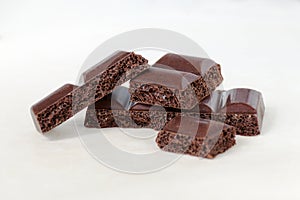 Pieces of porous chocolate on a white background