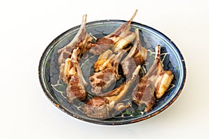 Pieces of rack of lamb are on the old plate