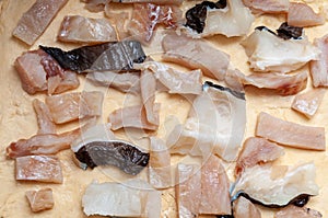 Pieces of raw fish are laid out on dough