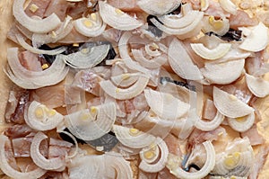 Pieces of raw fish are laid out on dough