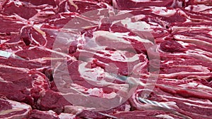 pieces of raw pork fillet in refrigerated display case in butcher shop, closeup view