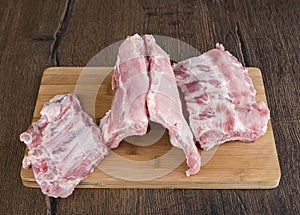 Pieces of raw pork ribs on a wooden cutting board