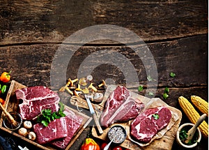 Pieces of raw steak prepared on wooden board