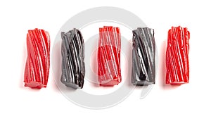 Pieces of Red and Black Licorice on White Background