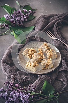 Pezzi da rabarbaro crollare torta sul piatto sul grigio decorato lilla fiori 