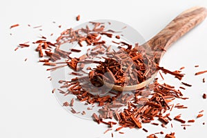 Pieces of sandalwood on a wooden spoon on a white background