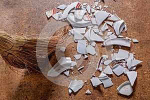 Pieces of shattered dishes. Fragments of the broken white ware on the floor.