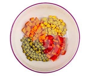 Pieces of pepper, carrot, green peas, corn in ceramic bowl isolated on white. Top view