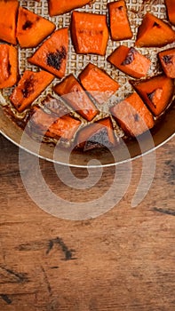 Pieces of sweet pumpkin baked with sugar for Halloween dinner. Healthy Vegetarian food. Autumn warm dish as a dessert. Selective