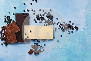 Pieces of three different chocolate bars and  chocolate chips
