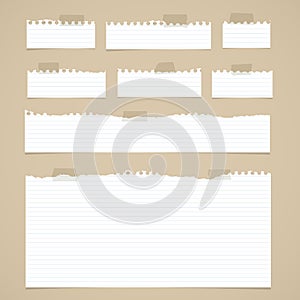 Pieces of torn white lined notebook paper with sticky tape on brown background
