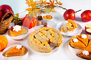 Pieces of traditional american homemade autumn apple and pumpkin pie for Thanksgiving day or Halloween