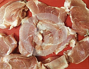 Pieces of traditional red meat cut from tenderloin on a red cutting board