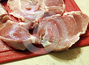 Pieces of traditional red meat cut from tenderloin on a red cutting board