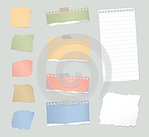 Pieces of various gray and colorful torn note paper with adhesive tape are stuck on background