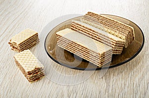 Pieces of wafer, brown saucer with wafers on wooden table