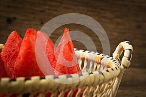 pieces watermelon in basket on old wooden