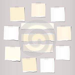 Pieces of white and beige torn note, notebook paper sheets stuck on grey background