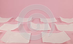 Pieces of white toilet paper on a pink toi. Toilet paper background.