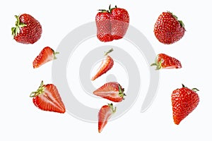 Pieces and whole strawberries isolated on a white in a chaotic manner