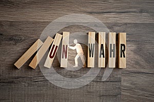 Pieces of wood with the german words for true and untrue - wahr unwahr on wooden background