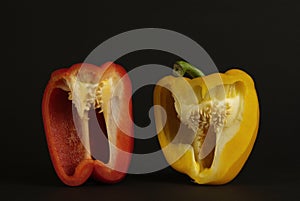 Pieces of yellow and red peppers on a black background