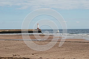 Pier and beach with old sailing yacht at Berwick-upon-Tweed