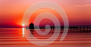 Pier on a beach by sunset