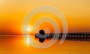 Pier on a beach by sunset