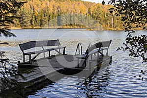 pier with benches on a forest lake in the autumn forest