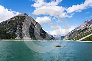 Pier with benches, Livigno lake with Corno Brusadella Mountain, Italy photo