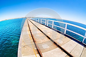 Pier in blue ocean water with fisheye horison