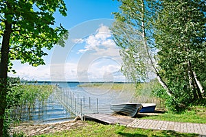Pier and boats on the lake on a sunny summer day. Braslav lakes. Belarus