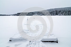 Pier covered of snow in the frozen lake of Sognsvann, Oslo photo