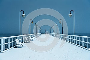 Pier covered with snow. Snowy, moody weather.