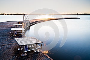 Pier at lake with natural swimming pool al sunrise