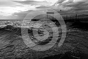 Pier on a lake with stormy weather and big waves