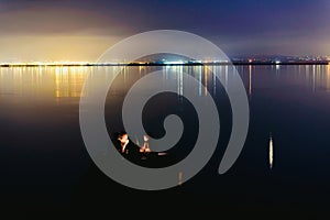 Pier on a lake at sunset with calm water and reflections of relaxing lights