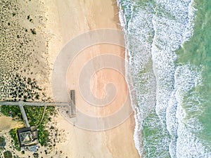 Pier leading to sandy beach and waves in Quinta do Lago, Almancil, Algarve, Portugal photo