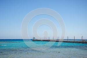 Pier leading to the sea on a sunny day/empty pier overlooking the sea on a sunny day