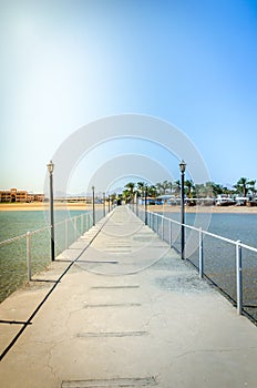 Pier leading to the sea on a sunny day/empty pier overlooking the sea on a sunny day