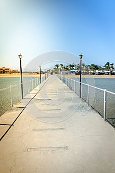 Pier leading to the sea on a sunny day/empty pier overlooking the sea on a sunny day