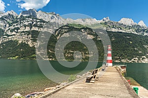 Pier and lighthouse at Lake Walen (Walensee) with view to the Churfirsten, Switzerland