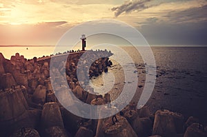 Pier with lighthouse at sunset