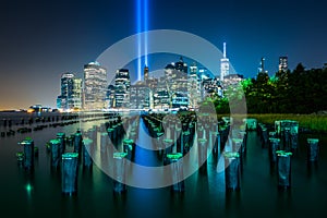 Pier pilings and the Tribute in Light over the Manhattan skyline