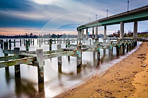 Pier posts in the Severn River and the Naval Academy Bridge, in