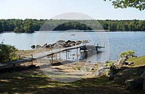 Pier and rocks on rocky shore of Lake Sebago, Maine