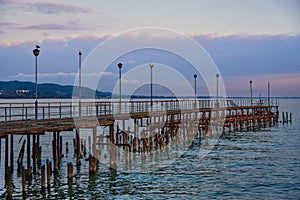 A pier stretching far out to sea against the sunset.