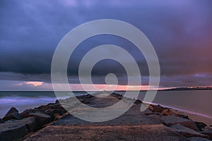 Pier to famous old farol de Portimao molhe este under gloomy sunset photo