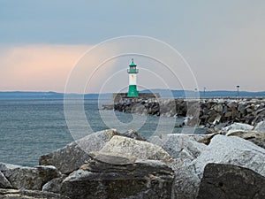 The pier in the town harbor of Sassnitz on the island of Rugen with the green and white lighthouse Ostmolenfeuer, Germany